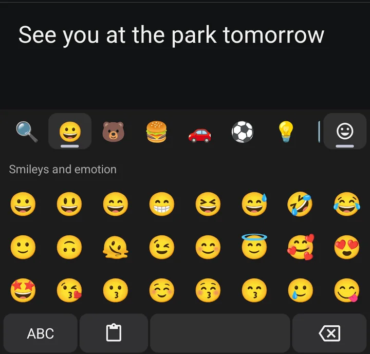 The emoji panel in place of the keys: a search button, category tabs and a grid of faces.