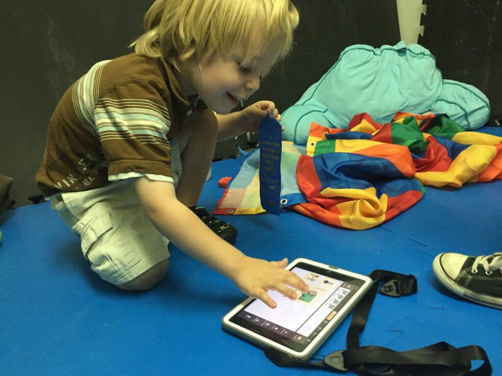 An Avaz AAC communication tablet being used during a therapy session.